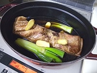鍋にねぎ、生姜、調味料、水、肉を入れ弱火で煮る