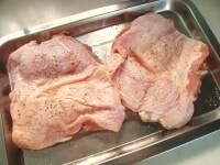 バットに鶏もも肉を並べ、塩、タイム、ローズマリーをふり、5分程おきます。<br />