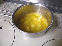 バターと砂糖が溶けたら、柚子の皮袋を取り出し絞ります。熱いので注意してください。<br />
薄切りのりんごを加え、弱火でかき混ぜます。りんごに透明感が出たら火を止めます。<br />