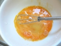 耐熱どんぶりに卵を割り入れ、泡だて器か箸で、なるべく泡を立てないように気をつけながら、よく溶きほぐす。<br />