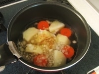 鍋に水、コンソメ、じゃがいも、にんじん、たまねぎを入れて火にかけ野菜が柔らかくなるまで茹でます。<br />