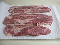 豚肉はロース肉でもバラ肉でもOKです。肉の厚さは1センチ程です。両面に塩と胡椒を揉みこみます。10分ほどおきます。<br />