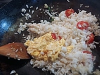 タイ米、トマト、１の卵を入れて軽く炒めたら、ナンプラー、シーズニングソース、塩、こしょうを入れて味を調える。小ねぎを入れて軽く炒め、器に盛る。<br />
きゅうり、ライムまたはレモン、小ねぎの白い部分を添える。<br />
ナンプラー、赤唐辛子を合わせたものも添え、好みでかけながら食べる。