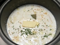 じゃがいも、玉ねぎ、スープの素、塩、コショウ、パセリ、ローリエ、バターを入れて炊く。<br />