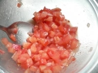 トマトを刻んでザルに上げて水気を切ってボウルにあけ、玉ねぎのみじん切りを加え、塩、こしょう、砂糖、油、酢を加えて混ぜる。<br />