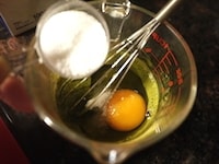 卵とグラニュー糖を加え、グラニュー糖のざらざらがなくなり、全体が均一になるまでよく混ぜます。