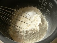 内釜に強力粉、薄力粉、イースト、砂糖、塩を入れて泡だて器でグルグル混ぜる。<br />