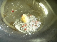 フライパンを火にかけ、油とニンニク、赤唐辛子を入れて炒めて香りを出す。<br />
