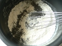 内釜に強力粉、イースト、砂糖、塩、スキムミルク、黒すりごまを入れて泡だて器でグルグル混ぜる。バターは室温で柔らかくしておく。<br />