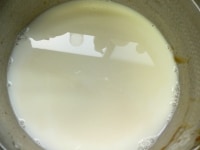 カラメルソースを作った鍋に、牛乳と砂糖を加え、少し温めて砂糖を溶かす。<br />