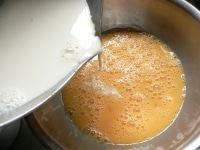卵をよく溶きほぐし、（4）の牛乳を入れて混ぜ、バニラエッセンスを混ぜる。<br />