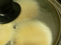 煮立って蒸気が上がった蒸し器に入れ、水滴がプリンの上に落ちないように蓋を少し斜めにして、弱火で11～12分蒸す。<br />