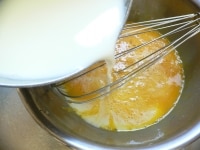 小鍋に牛乳と砂糖を入れて温め、砂糖が溶けたら火を止め、生クリームを混ぜる。ボウルに卵黄を取ってよく混ぜ、混ぜながら牛乳液を注ぎ入れる。バニラエッセンスを混ぜてザルでこす。<br />