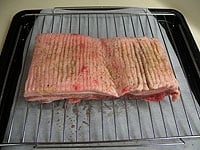豚バラ肉を冷蔵庫から出し、皮面に幅5～8ミリ・深さ1センチほどの切れ目を入れます。塩、砂糖、胡椒を合わせてよくすりこみます。常温で30分ほど置きます。<br />