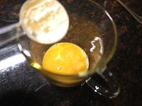 溶きほぐした卵をマグカップに入れ、ホットケーキミックス、ベーキングパウダーを加えます。