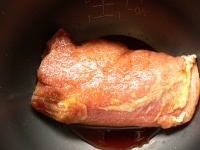 生姜、ニンニク、ねぎをどけて　豚肉を内釜に入れる。味付け調味料と（1）の漬け汁を大さじ1まわしかけ、普通に炊く。<br />