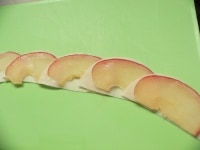 餃子の皮1枚にりんご1枚をのせ、端を1cmぐらい重ねながら、6～8セット並べていく。<br />
