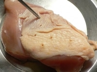 鶏肉は皮を中心にブスブス刺して穴を開けて、味が染みやすく皮が縮みにくいようにする。<br />