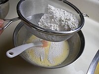 (4)に粉類を振るいながら加え、混ぜ合わせます。