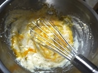 ボウルに絹ごし豆腐を入れ、なめらかになるまで泡立て器で混ぜます。卵を加え、全体がさらになめらかになるまでよく混ぜます。
