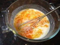 卵黄を加え、よく混ぜます。全体がなめらかに均一に混ざったら、残り半量の牛乳も加え、よく混ぜます。