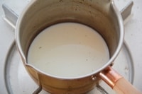小鍋の内側をサッと濡らし、牛乳、グラニュー糖、バニラビーンズを入れて沸騰直前まで温める。<br />