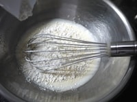 ホットケーキミックスを2~3回に分けて加えます。その都度、だまにならないように、なめらかになるまで泡だて器で混ぜます。