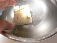 切った豆腐は手でそっと持ち上げ、水の中に入れておく。<br />