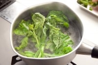 鍋にたっぷりの湯を沸かし、塩を加える。湯が沸騰している状態で菜の花の茎部分を加えて30秒、つぼみ部分を加えてさらに30秒程度茹でる。<br />