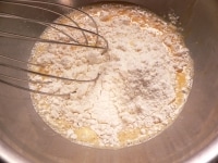 水を入れて混ぜ、小麦粉を入れて混ぜる。<br />