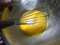 ボウルに卵を入れ、溶きほぐします。グラニュー糖を加え、グラニュー糖のざらざらがなくなって、全体がふんわりと白っぽくなるまで、泡立て器でよく混ぜます。