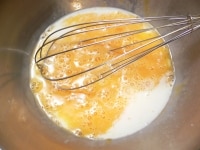 重さをはかったボウルで卵をほぐし、牛乳とバニラエッセンスを混ぜる。<br />
