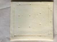 長方形の冷凍パイシート1枚を伸ばし、正方形を2枚とる。 「」型(かぎかっこ型)に切れ目を入れます。