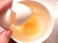 容器に水を入れ、冷蔵庫から取り出した卵を割り入れる。<br />
