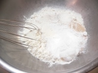 ボウルに強力粉、米粉、イースト、砂糖、塩、ミルクを入れて泡立て器でグルグル混ぜる。<br />