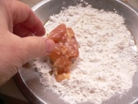 片栗粉と小麦粉を混ぜあわせる。鶏肉にまぶしつけ、余分な粉をはたいて落とし、(10)のフライパンに、皮目を下にして並べる。<br />