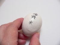 卵をまな板に軽く打ちつけて、ぐるりと一周にヒビを入れ、水の中で剥く。<br />
<br />
<b>一カ所にヒビを入れるよりも、ぐるりと一周にヒビを入れた方が手早く剥ける</b>。水の中での方が剥きやすく、付着した小さな殻が水の中に落ちるのも良い所。<br />