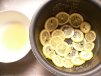 内釜に(1)のレモンを敷き詰める。<br />
<br />
残ったシロップは、電子レンジ(600W)で1分10秒ほど加熱して、冷ましておく(はちみつレモンシロップ)。<br />
