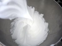 溶きほぐした卵白をハンドミキサーの高速から徐々に中速で泡立てます。2～3回に分けてグラニュー糖大さじ2を加え、ツノがピンと立つ状態のメレンゲを作ります。