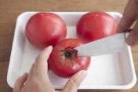 トマトのヘタを取り除く。きゅうりを1cm程度の角切りにする。<br />