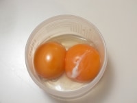 卵は白身と黄身に分け、黄身を小さい容器に入れる。<br />