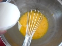 鍋に入れた牛乳の縁がふつふつとしてきたら、沸騰する前に火を止めます。溶きほぐした卵に少しずつ加え、全体を混ぜます。