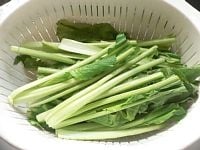 小松菜は洗って根元を切り落とし、半分に切る。 