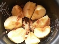 内釜にバターかサラダ油を薄くぬり、りんごを並べる。シナモンをふりかけ、レーズンとナッツを散らす。