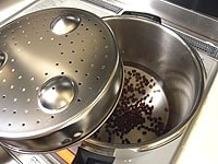 圧力鍋に下茹でしたささげと水500mlを入れます。豆類を煮るときは、専用すのこを裏返して落し蓋として使います。蓋の圧力放出口などに豆のかすが詰まるのを防ぐためです。 