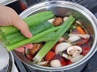 鍋に水、赤ワイン、【2】の野菜、大豆、ねぎの青い部分を加えて火にかけます。沸騰したら蓋をしないで弱火で30分煮こみます。