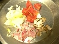 米は30分前にといでザルに上げておく。トマトは1～2cm角に、しいたけは5mm～1cm角に切り、玉ネギは粗みじん切り、ベーコンは細切りにする。<br />