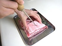 豚ばら肉は2等分します。肉の全面を串などで穴をあけます。