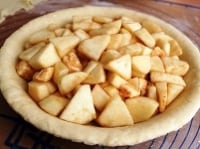 フィリングを作ります。皮をむき、くし切りにしたリンゴを、1cmの厚さにスライスします。バターは手で親指大にちぎり、砂糖、シナモンを合わせて全体に行きわたるようによく混ぜます。<br />
<br />
表面が平らになるように型に入れます。<br />
