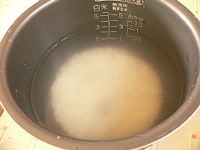 米をといで、おかゆ用の水加減をして、おかゆコースにあわせてスイッチを入れる。<br />